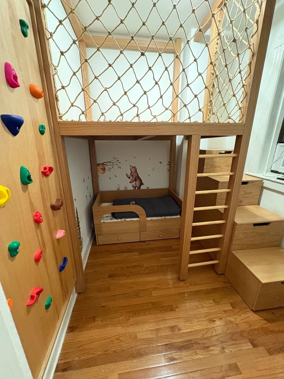 custom wooden loft bed with climbing wall and storage stairs