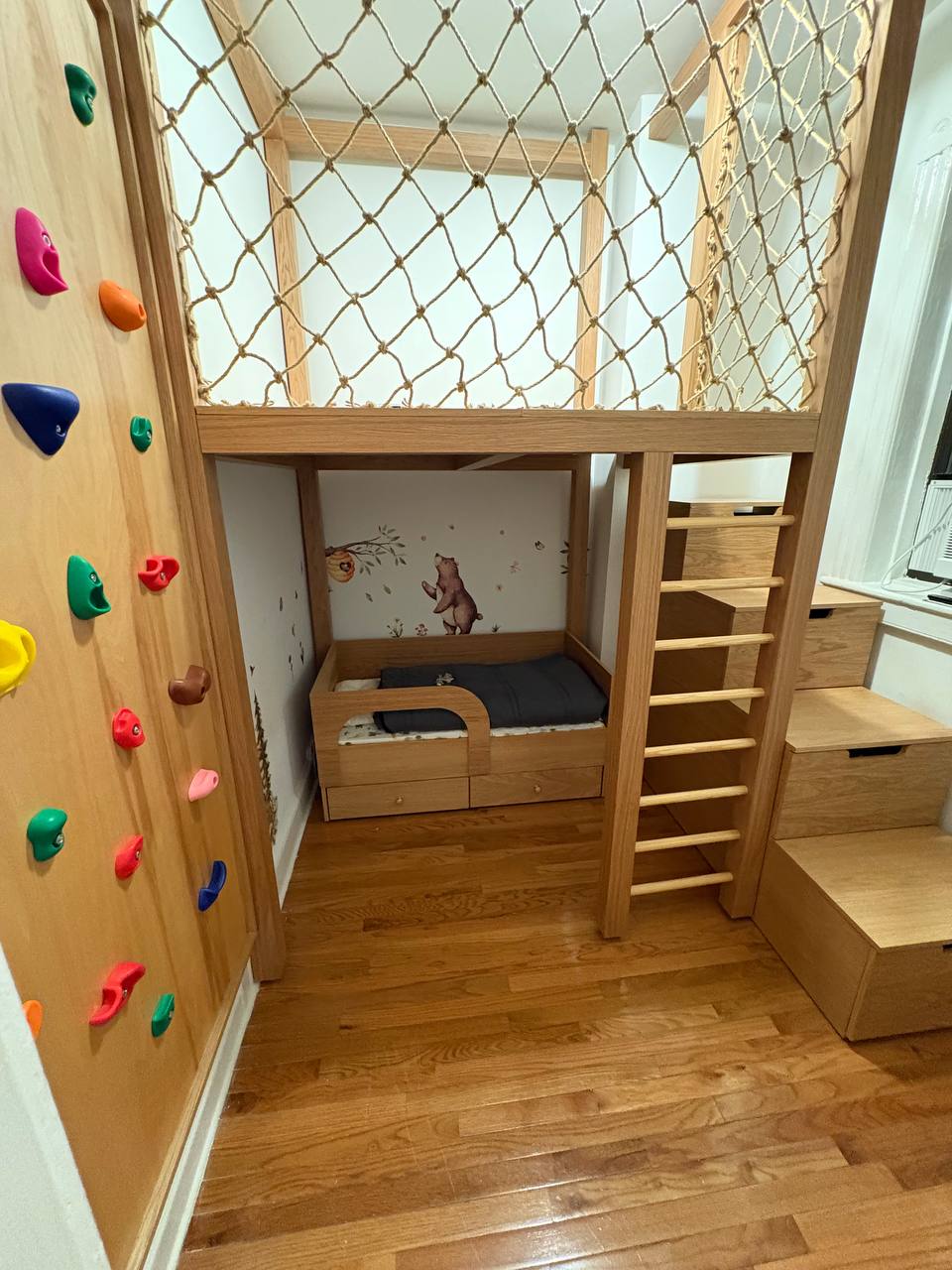custom wooden loft bed with climbing wall and storage stairs